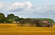 Farm Vehicle Spreads Fertilizer Over a Field
