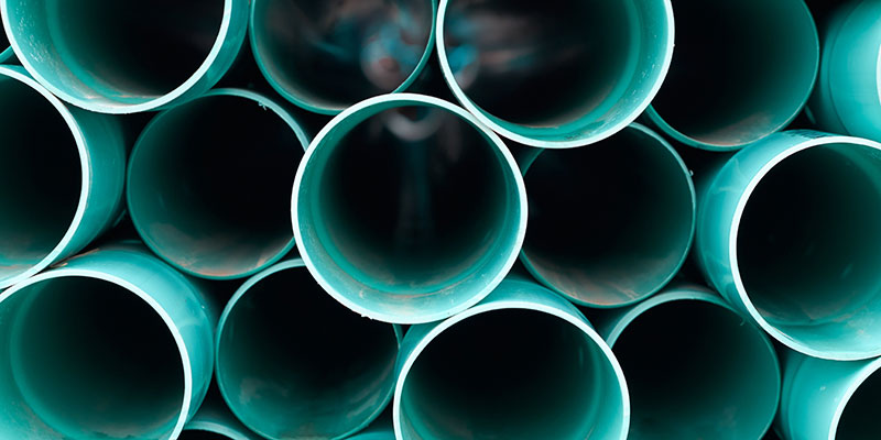 A large stack of blue drainage pipes